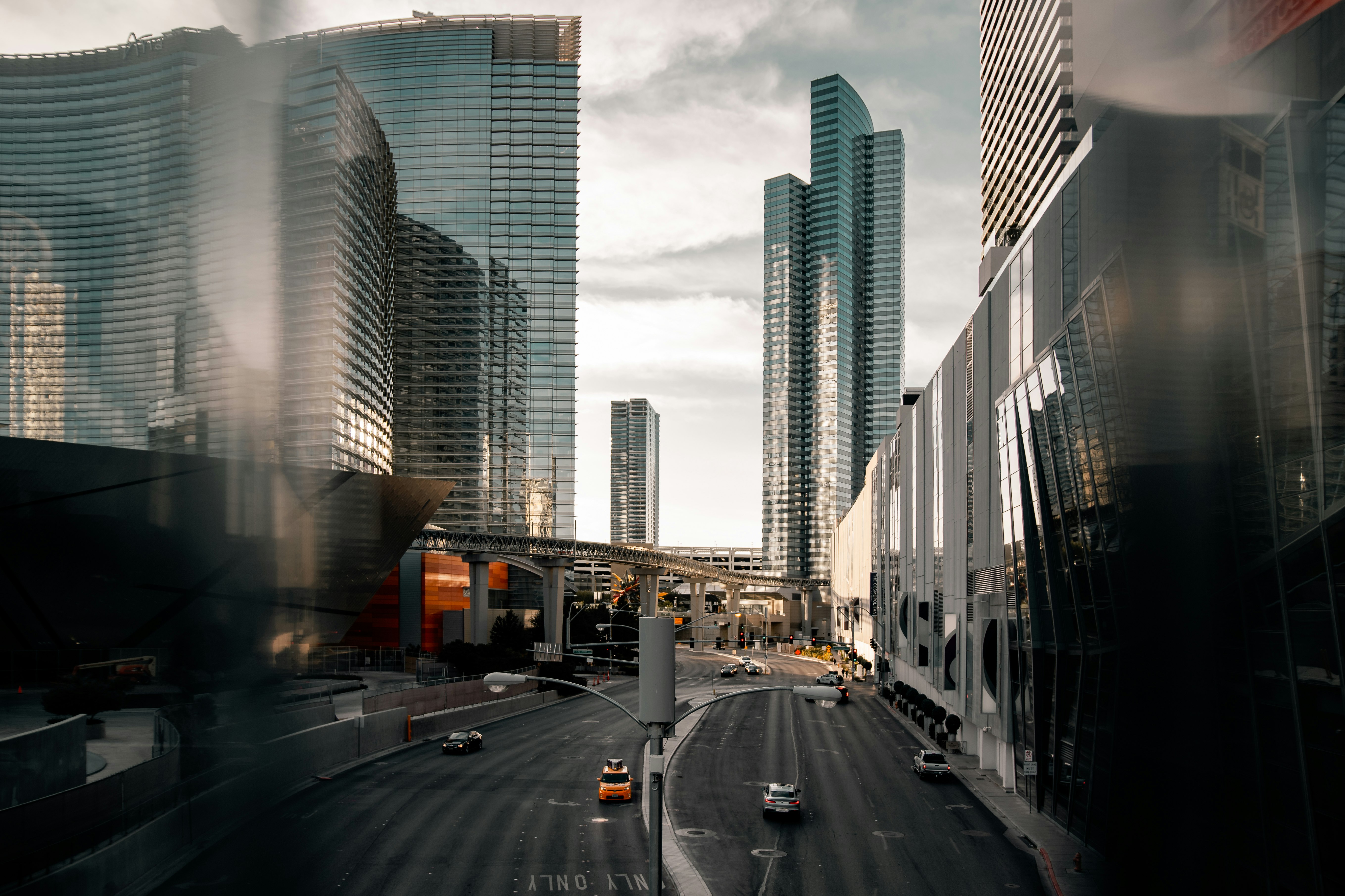 cars on road between high rise buildings during daytime